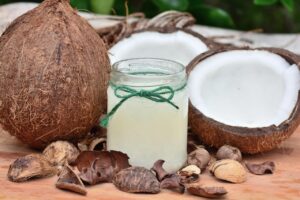 Immagine di un barattolo di olio di cocco con un cucchiaio, simbolo dell'oil pulling per denti sani.