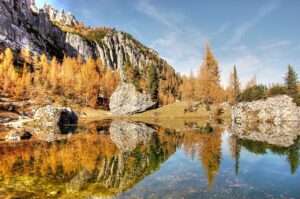 Lago di Braies con acque turchesi, circondato da montagne e foreste, ideale per una meta segreta.
