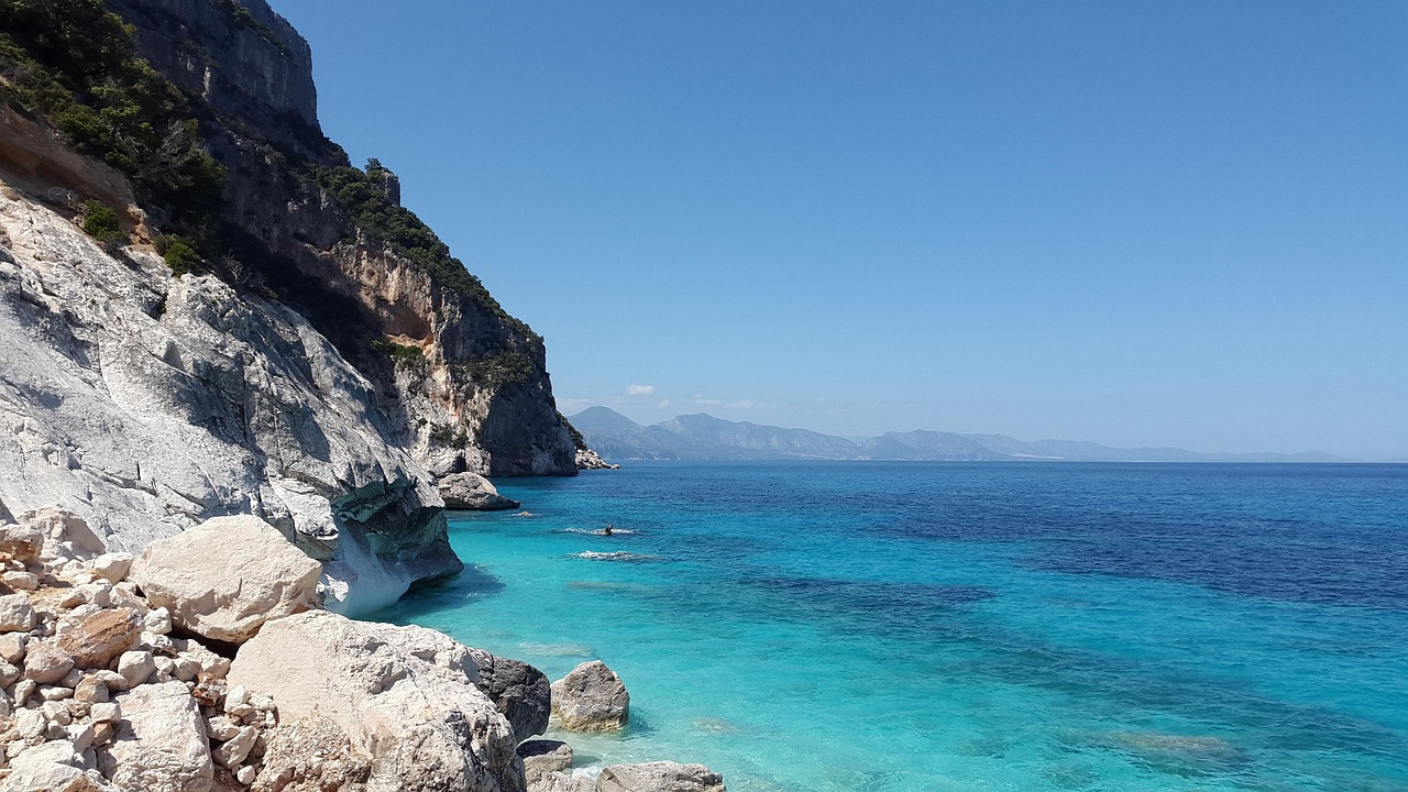 Vista panoramica della spiaggia di Cala Goloritzé con acque turchesi e scogliere imponenti.