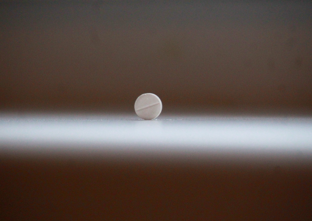 Immagine di un flacone di melatonina su un tavolo con un orologio in background, simboleggiando il ritmo circadiano.